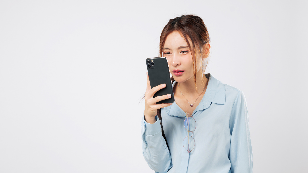 Person holding a smartphone close to their face, representing someone with low vision using mobile technology